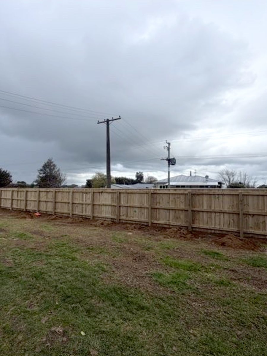After: long roadside timber paling fence replacing an open post and rail frame